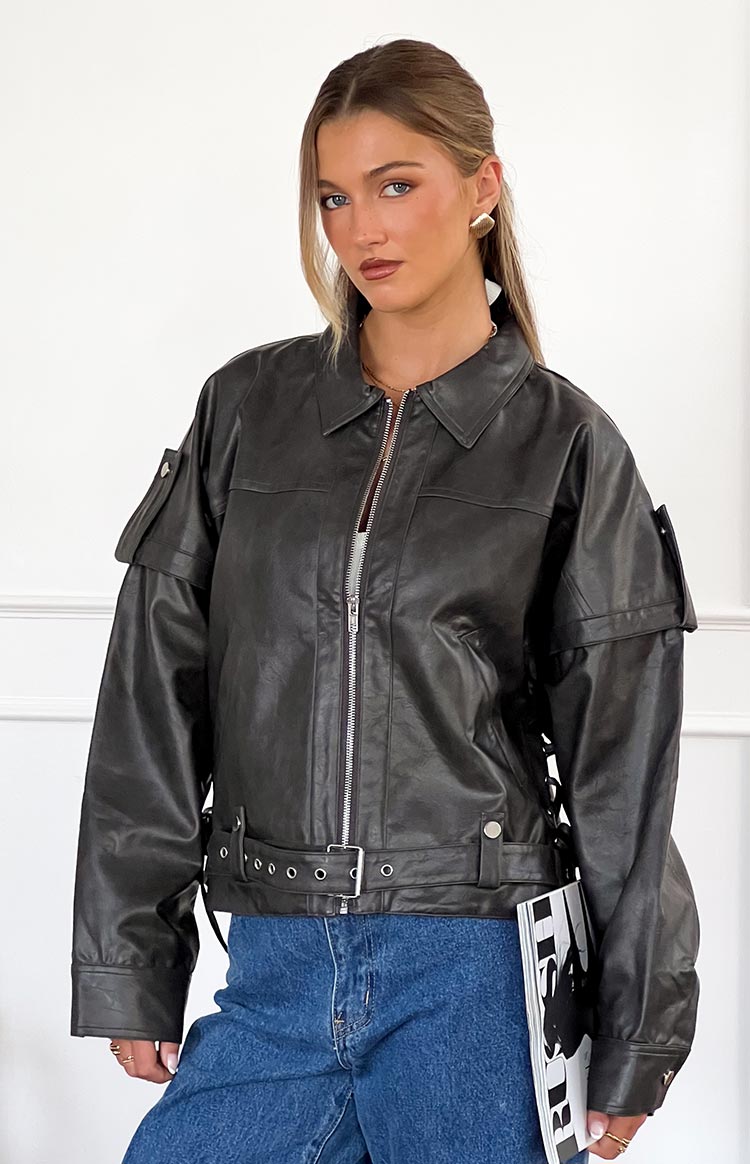 Washed black PU jacket with collared neckline, shoulder epaulets, and belted waist with lace-up sides