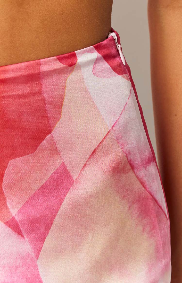 Close-up of the invisible side zipper closure on a pink abstract print mini skirt