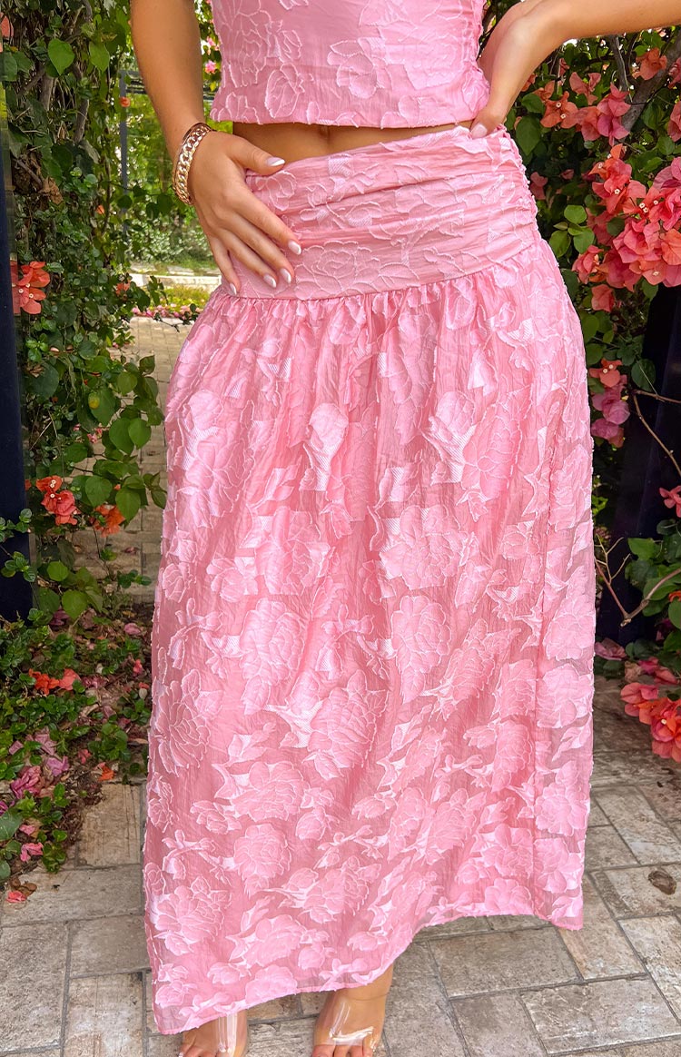 Close-up of the ruched elastic waistband and the textured floral pattern on the pink maxi skirt