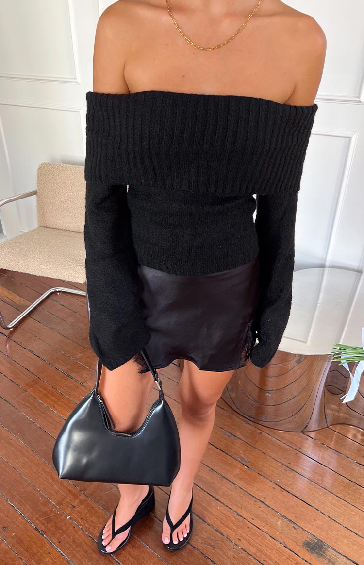 Black off-shoulder soft knit sweater with a wide ribbed fold-over neckline and long sleeves