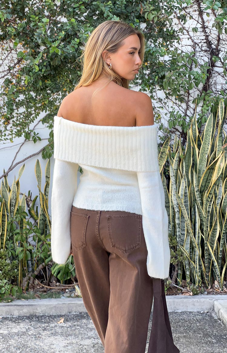 Rear view of a cream off shoulder sweater with a wide ribbed neckline and fuzzy knit texture