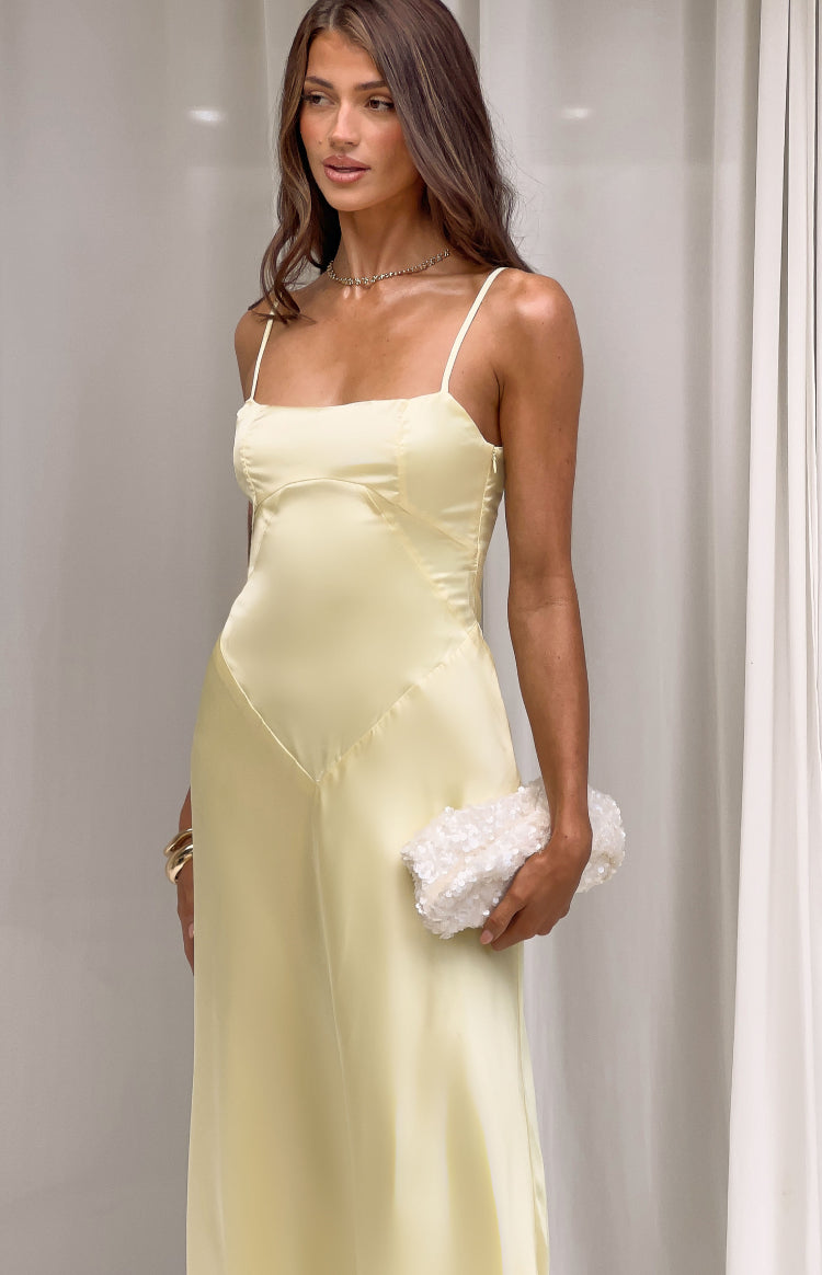 Yellow satin maxi dress with a square neckline, thin spaghetti straps, and V-shaped seam detail on the bodice