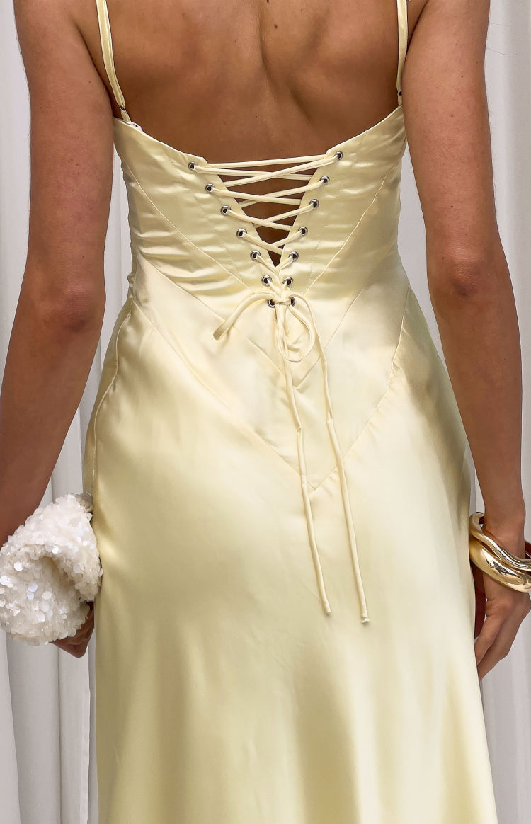 Rear view of a yellow satin maxi dress with a lace-up corset back and silver eyelets