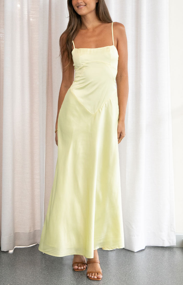 Yellow maxi dress with a square neckline, thin spaghetti straps, and a V-shaped seam detail