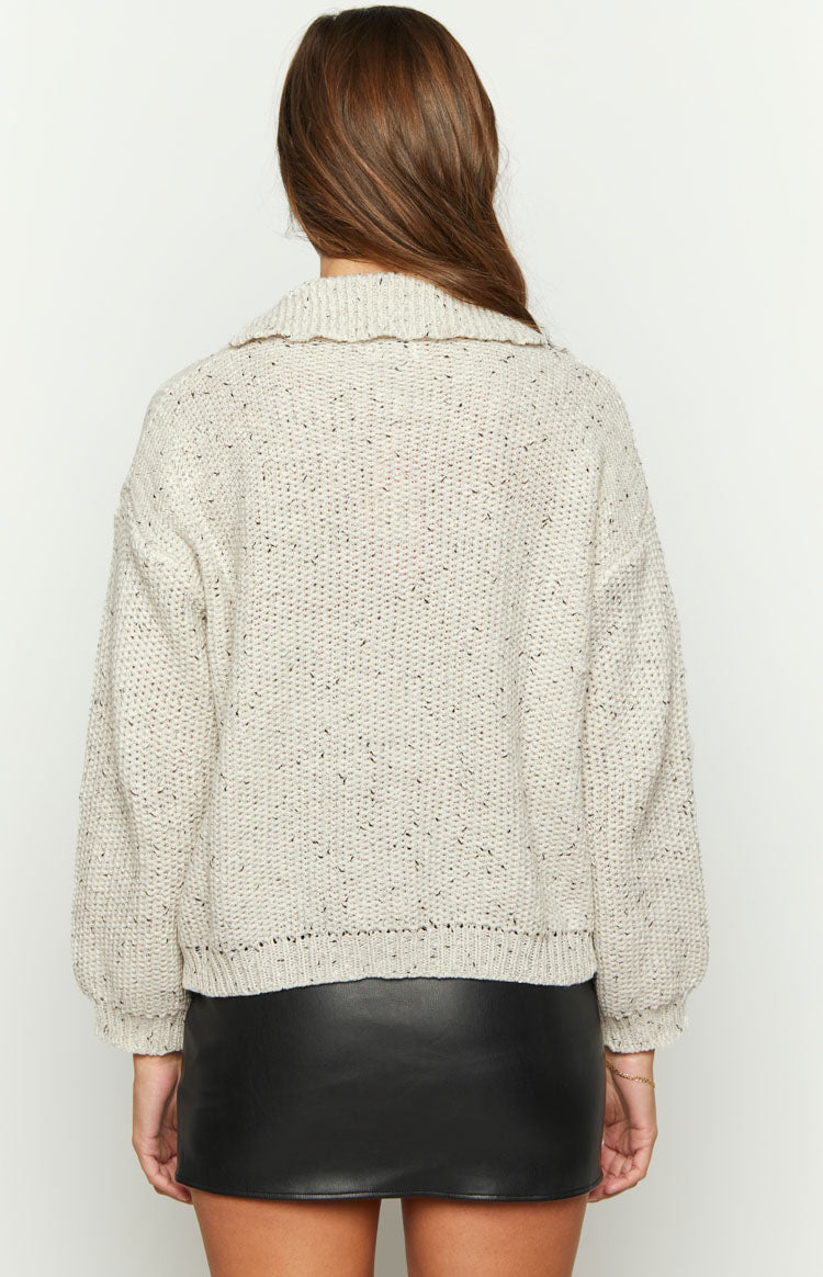 Back view of a light grey speckled knit sweater with a wide spread collar, dropped shoulders, and ribbed hem