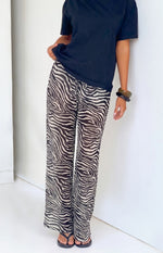 Sheer black and white zebra print wide-leg pants with a relaxed fit and flowing fabric