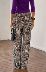 Rear view of black sheer zebra print pants with a relaxed wide leg and elasticated waist