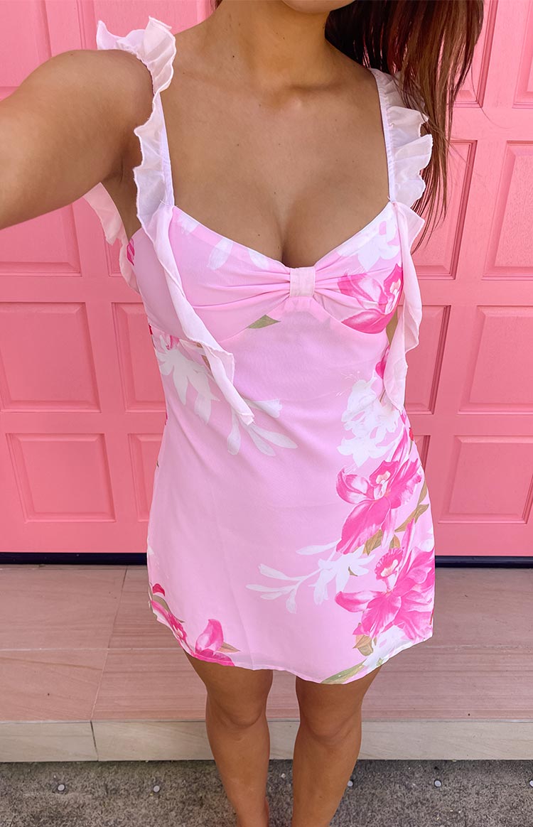 Pink floral chiffon mini dress with a sweetheart neckline, central bow, and delicate ruffled shoulder straps