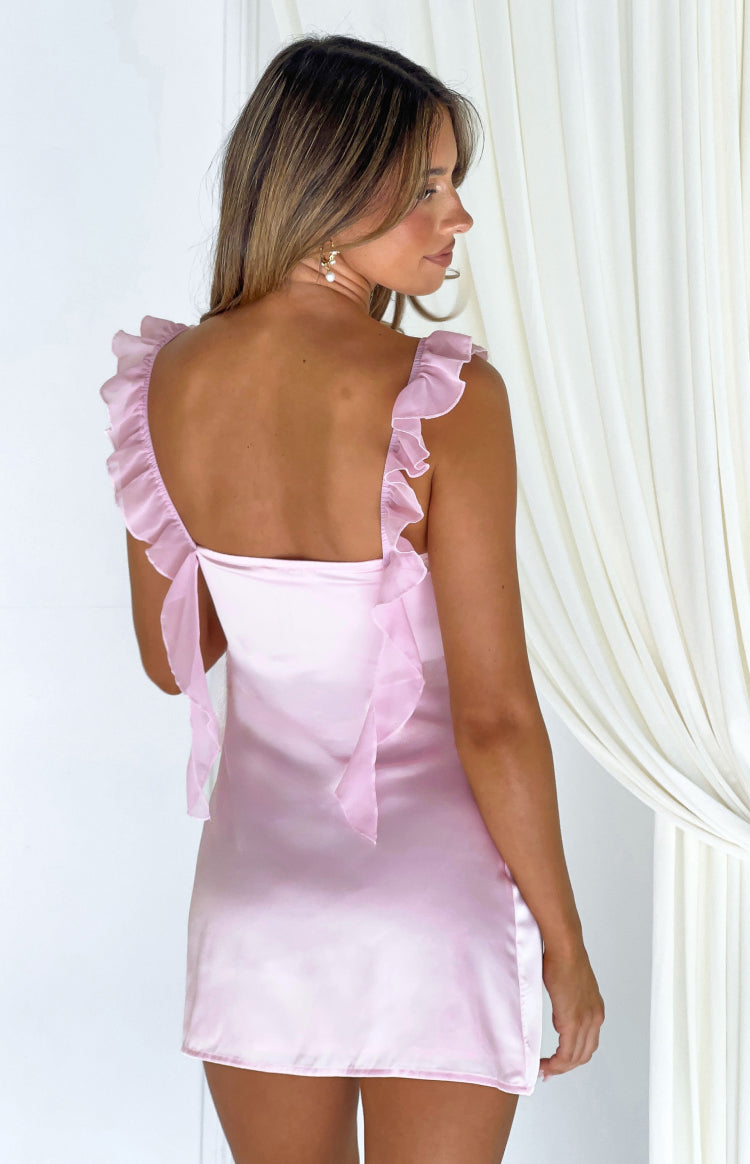 Back view of a pink satin mini dress featuring ruffled shoulder straps and a square tie-back