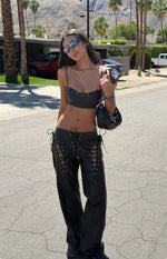 Black PU leather crop top with thin spaghetti straps and a scalloped neckline with silver eyelets