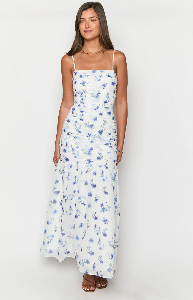 Front view of a white floral maxi dress with square neckline, spaghetti straps, ruched bodice, and flared hem