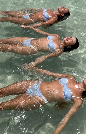 Blue gingham bikini bottoms with white lace trim, worn for swimming