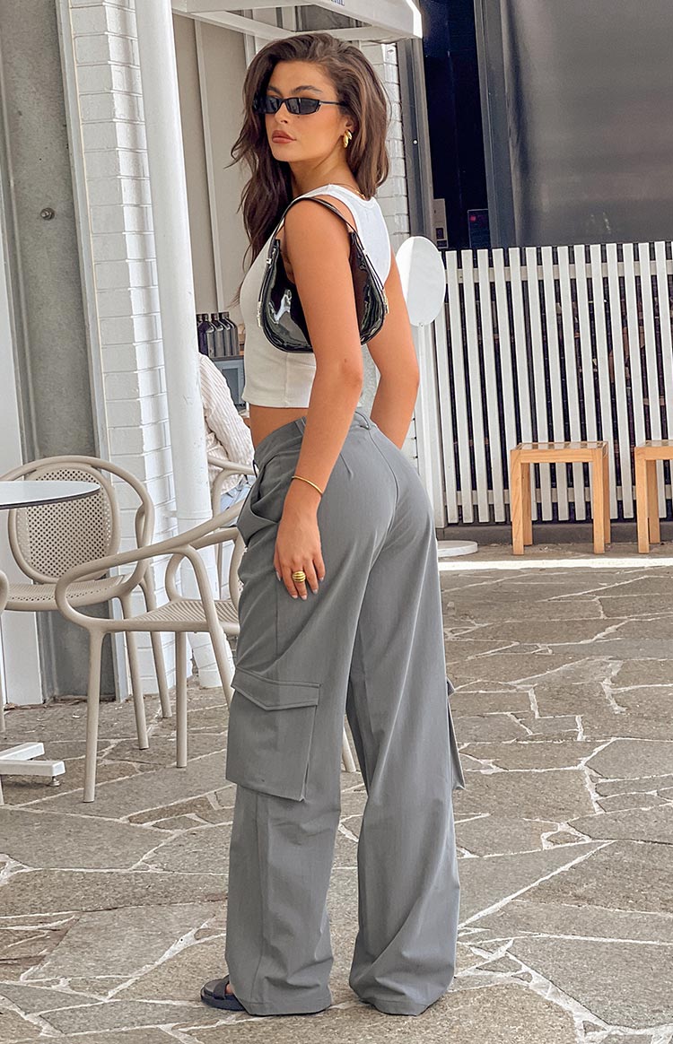 Side view of grey straight leg pants with cargo pockets, pleats at the waist, and a wide leg