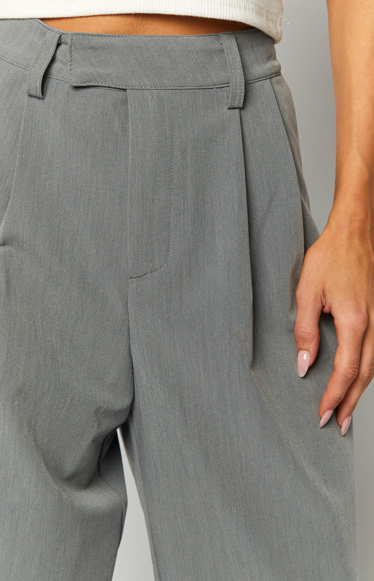 Close-up of the grey pants showing the single front pleat and waistband with belt loops