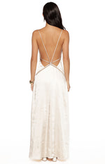 Rear view of a cream satin maxi dress with a low scoop back and criss-cross spaghetti straps, showing the delicate trim detail