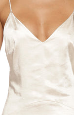 Close-up of the cream satin V-neckline and thin spaghetti strap of a maxi dress