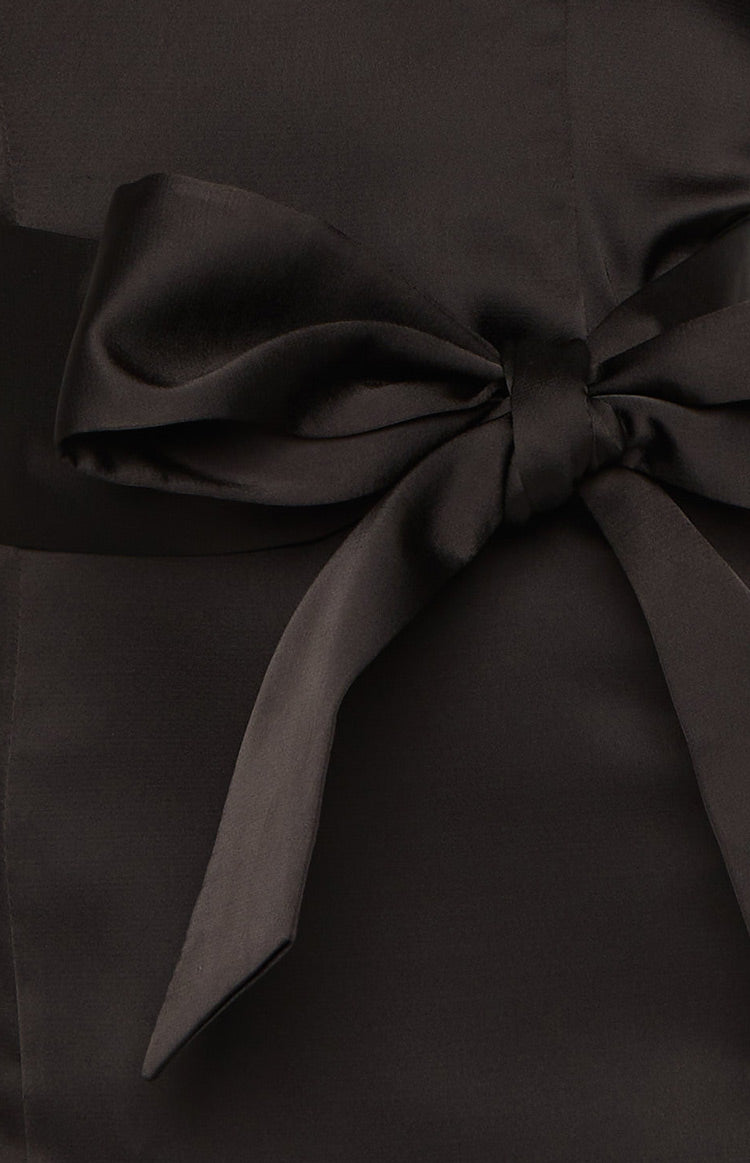 Close-up of the black satin bow detail on a black mini dress