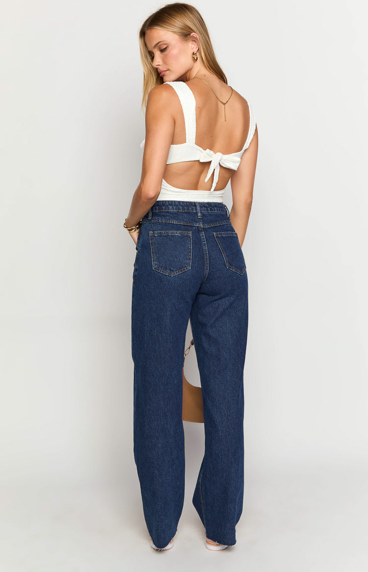 Rear view of dark blue high-waisted jeans with two back patch pockets and a straight leg fit