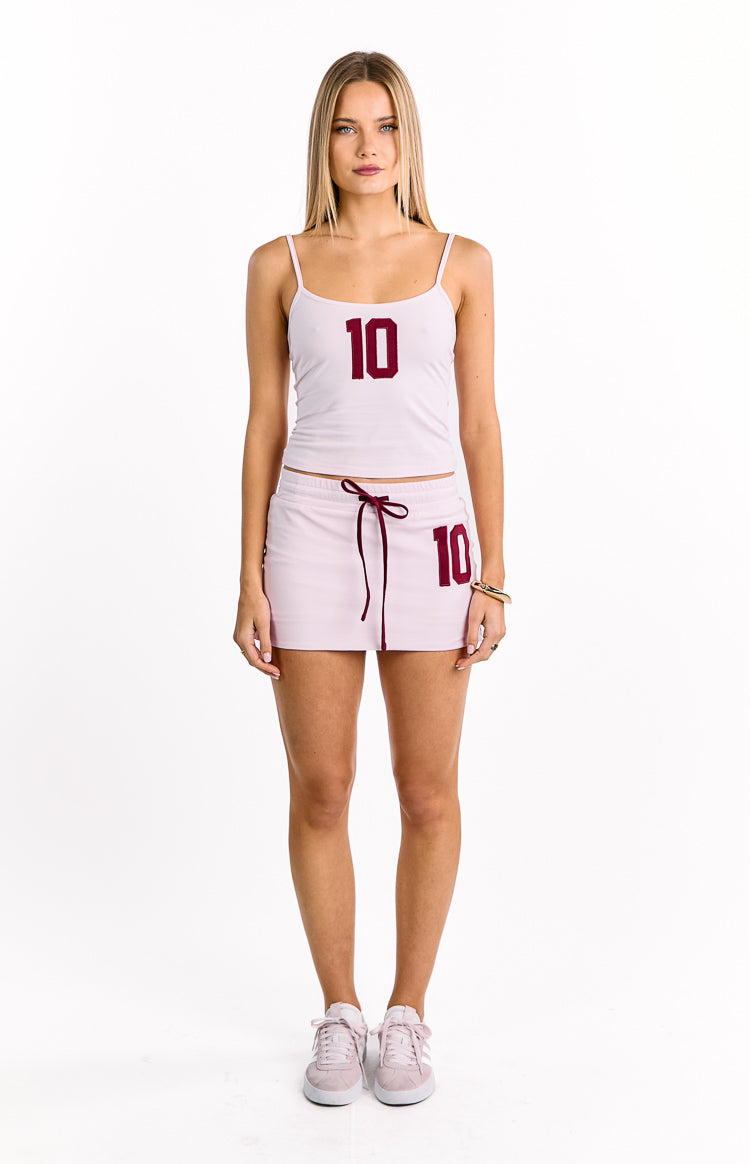 Front view of a fitted light pink jersey camisole with thin spaghetti straps and a red '10' graphic