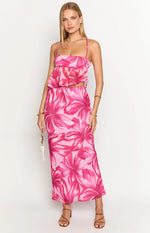 Front view of a light pink bandeau top with dark pink abstract floral print, a ruffled peplum hem and thin spaghetti straps
