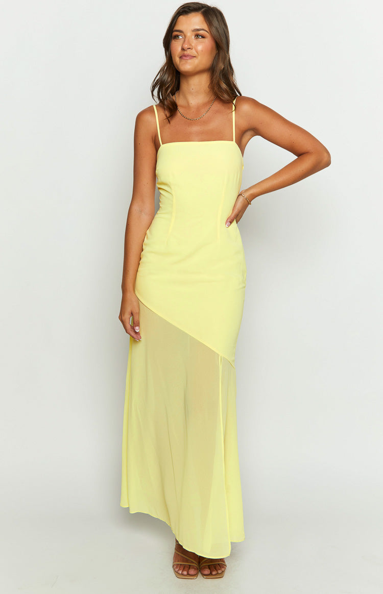 Front view of a yellow maxi dress with a square neckline, thin straps, and a diagonal sheer chiffon panel on the skirt