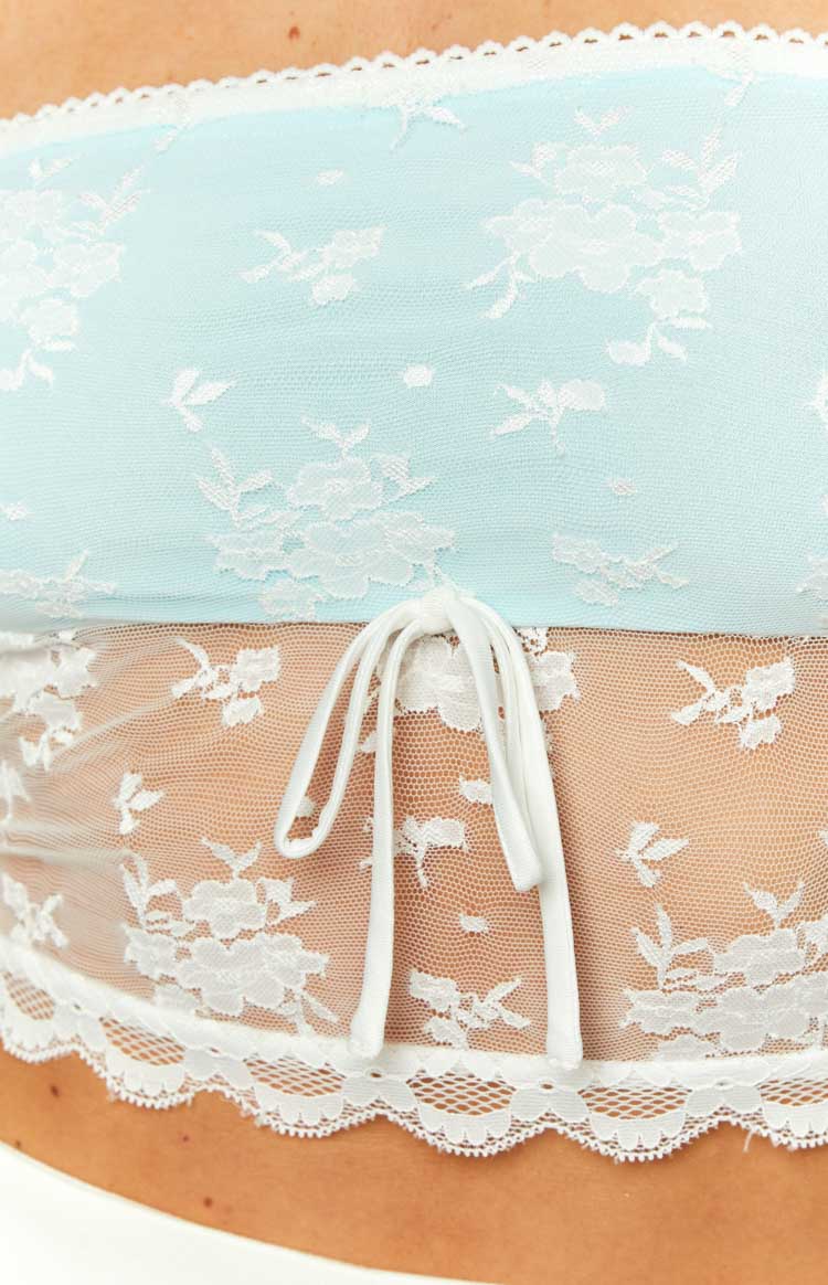 Close-up of the white floral lace tube top with a central drawstring, sheer lower panel, and scalloped trim