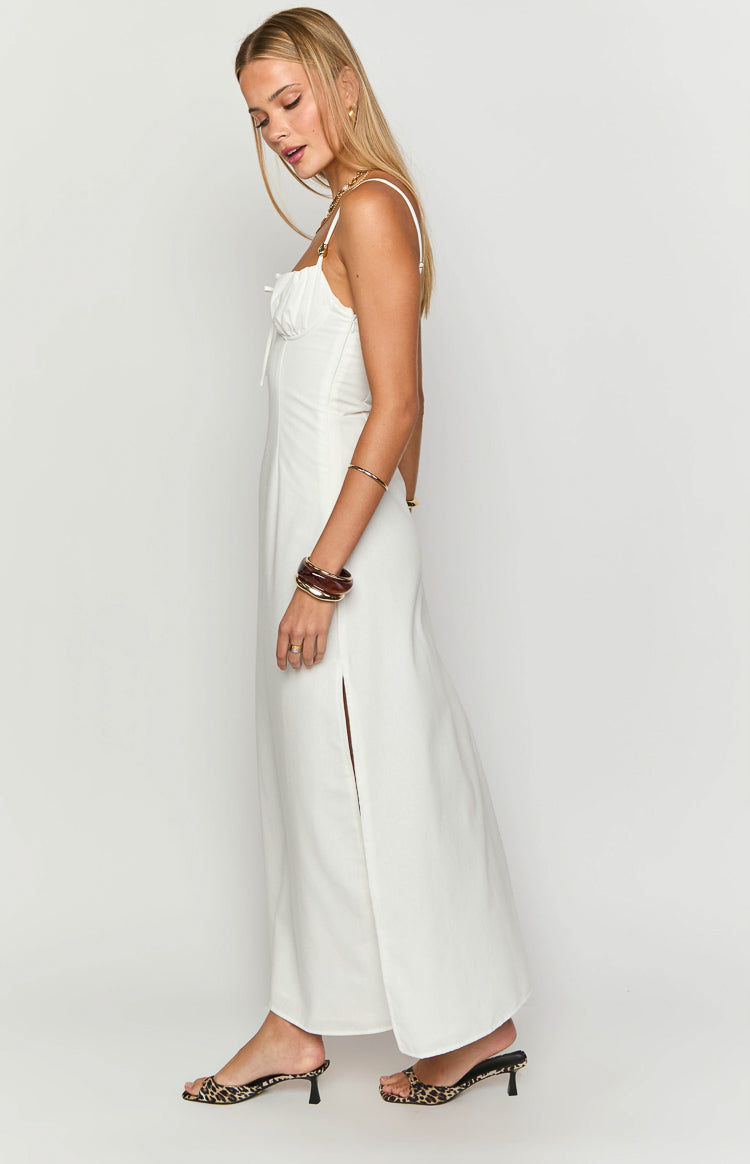 Side view of a white maxi dress showing the ruched bust, spaghetti straps, and high side slit