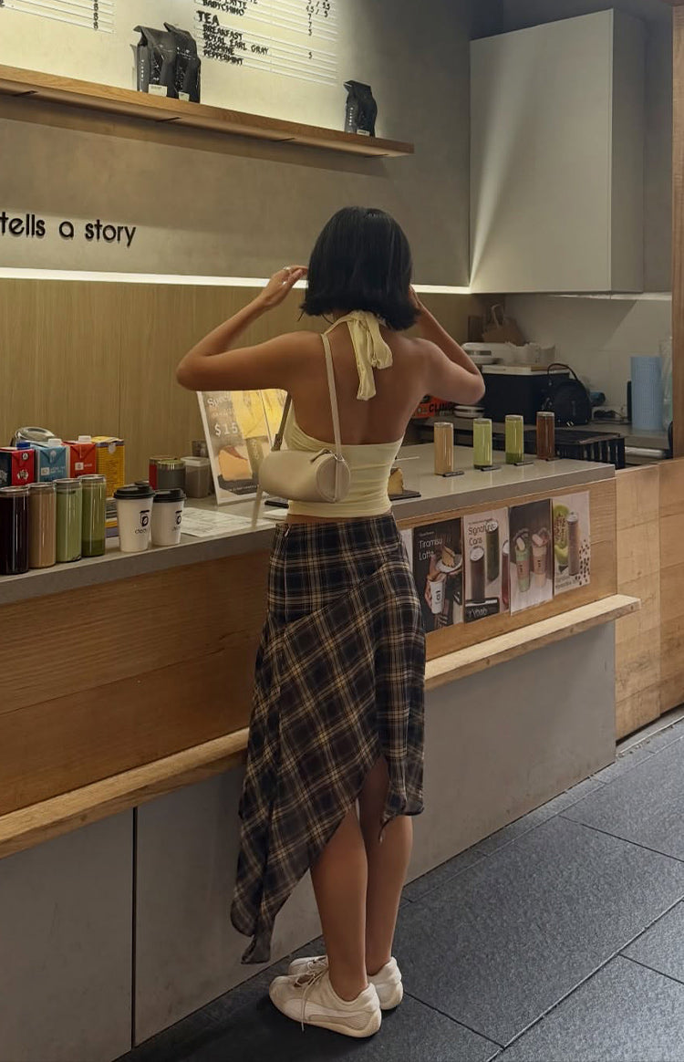 Rear view of a dark blue and brown plaid midi skirt, highlighting the asymmetrical hanky hem