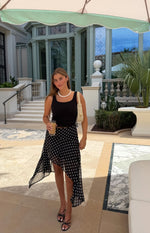 Front view of the black polka dot midi skirt with a flowy hanky hem