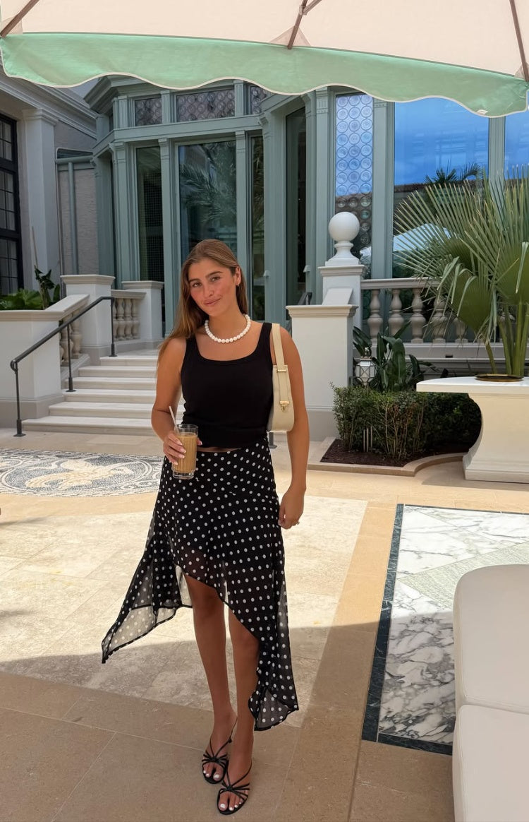 Front view of the black polka dot midi skirt with a flowy hanky hem