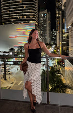 Flowy white polka dot midi skirt with an asymmetrical hanky hem and gathered tiers