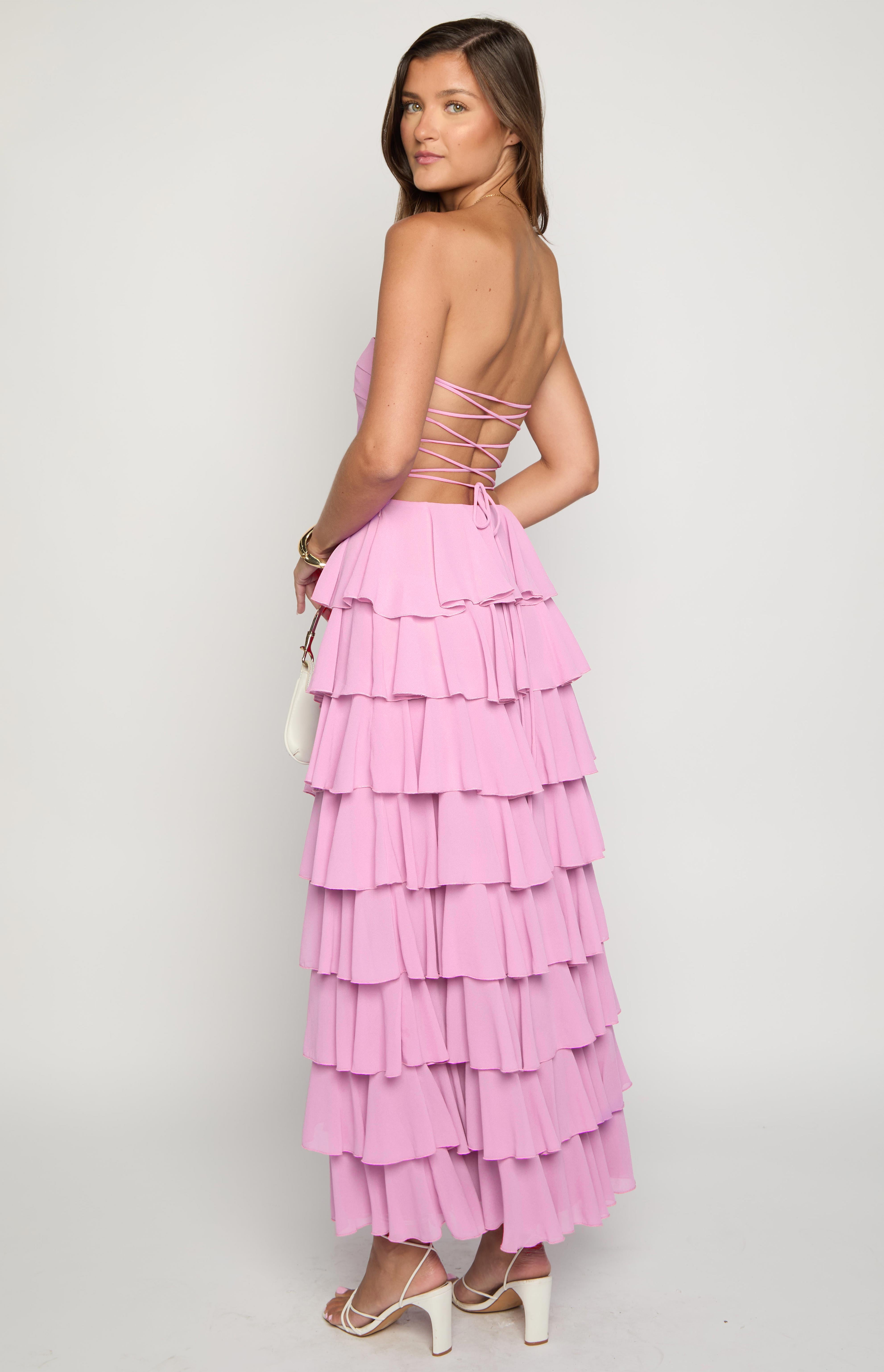 Rear view of a pink strapless maxi dress with a lace-up back and a tiered ruffle skirt