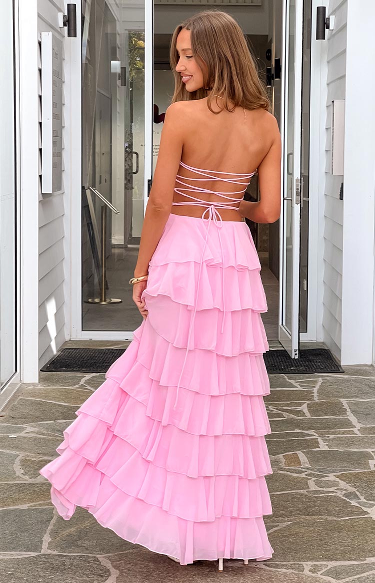 Rear view of a pink strapless maxi dress with a criss-cross lace-up back and a full tiered ruffle skirt