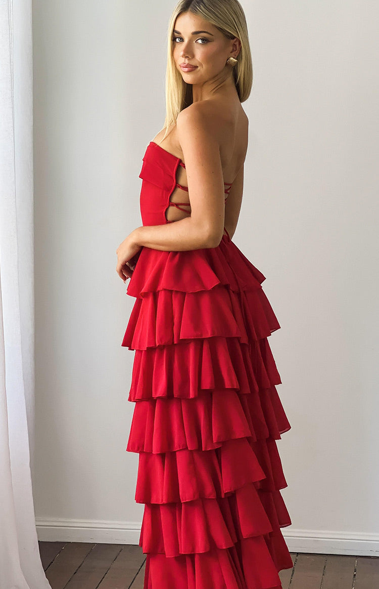 Side view of a red strapless maxi dress with side cutouts, lace-up bodice, and tiered ruffle skirt