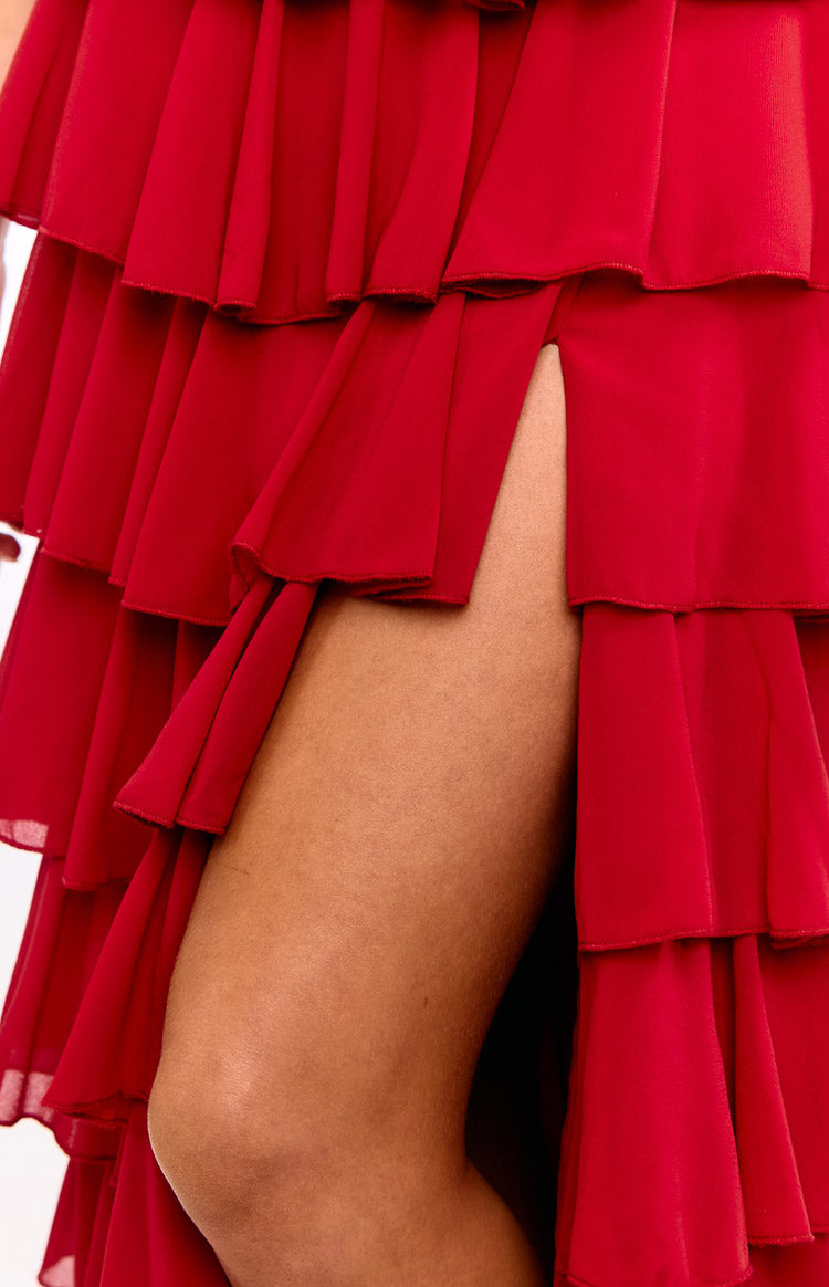 Close-up of the red tiered ruffle skirt of the maxi dress, showing the high leg slit