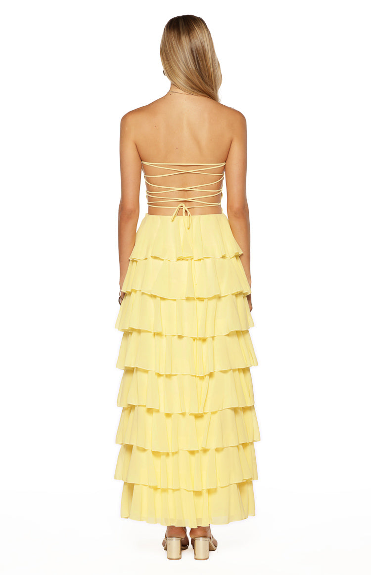 Rear view of a yellow strapless maxi dress with a criss-cross lace-up back and tiered ruffle skirt