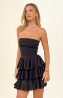 Rear view of a black strapless mini dress showing the criss-cross lace-up back and tiered ruffle skirt