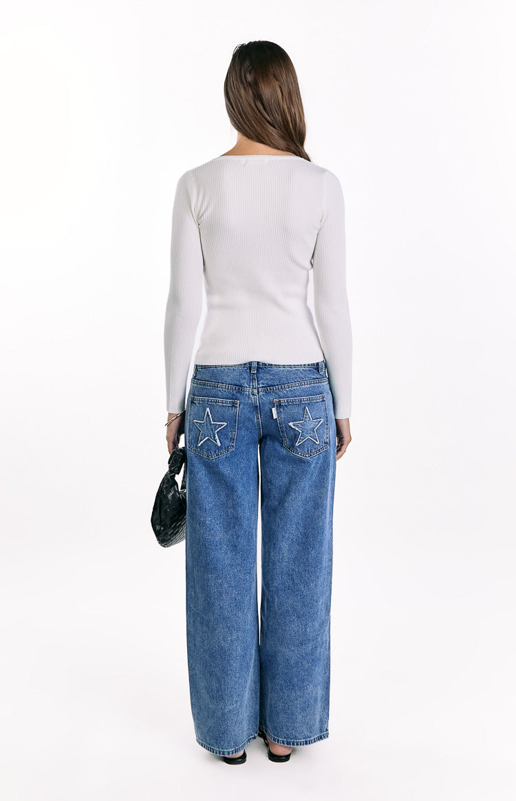 Rear view of a white ribbed knit long sleeve sweater with a fitted silhouette and subtle scoop back neckline