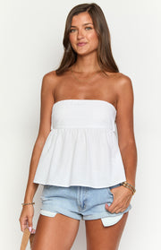 Front view of a white strapless top with a gathered peplum hem