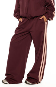 Beginning Boutique Kosie Burgundy and Pink Stripe Track Pants — burgundy wide-leg track pants with pink side stripes and elasticated waist