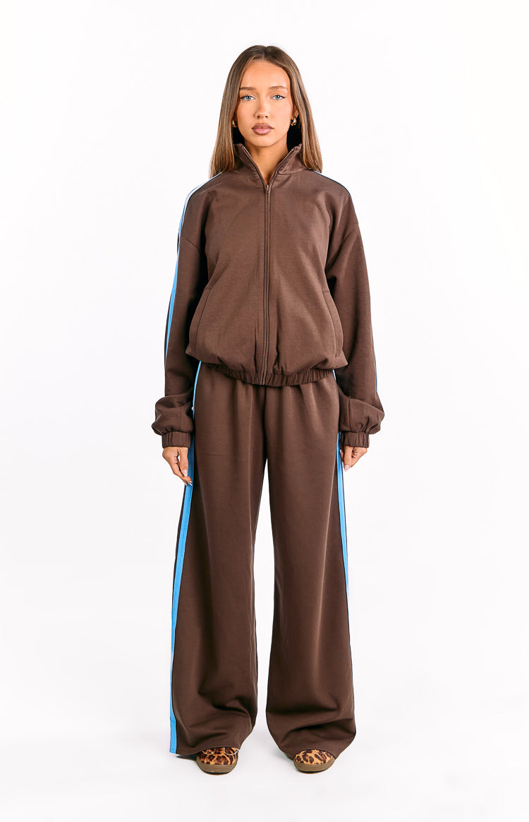 Full length chocolate brown wide-leg track pants with a blue side stripe and relaxed fit