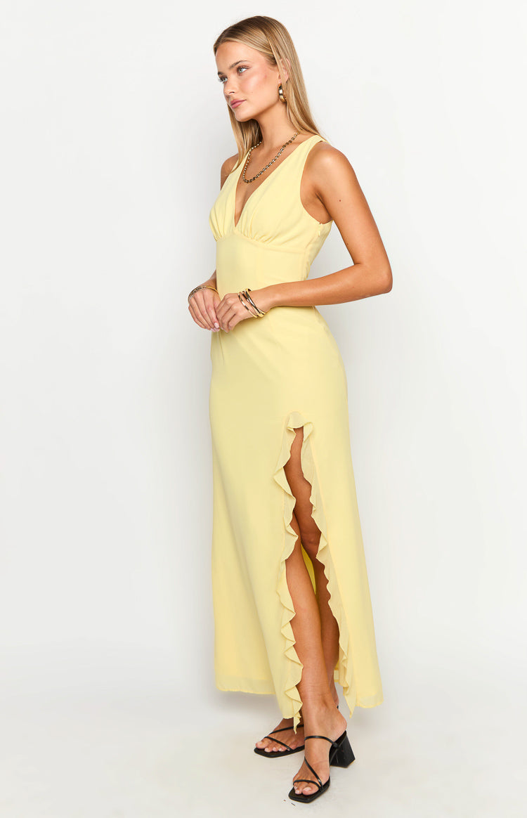 Side view of a yellow maxi dress showing the deep V-neckline and a high leg slit with a ruffled edge