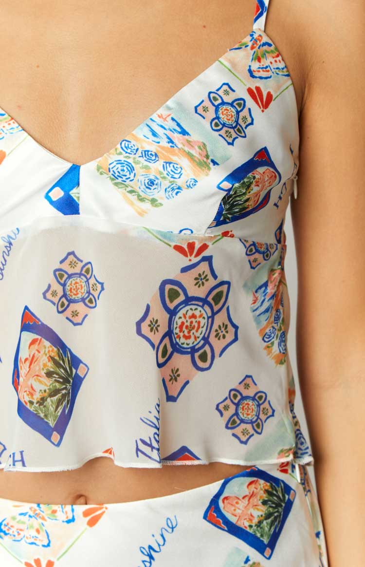 Close-up of the white satin crop top's colourful Italia print featuring geometric and floral motifs, with side zipper