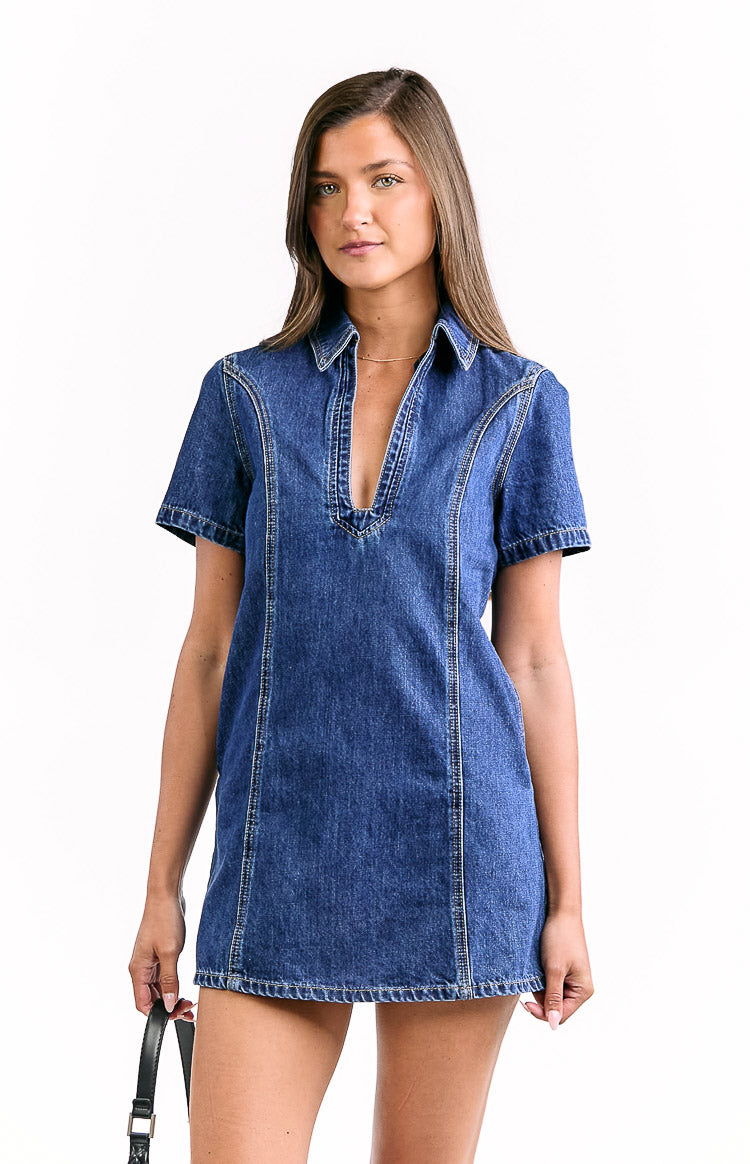 Front view of a dark wash denim mini dress with a deep V-neck, collar, short sleeves, and visible vertical seam details