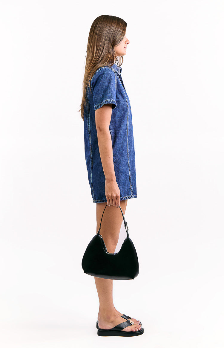Side view of a dark wash denim mini dress with short sleeves and a collared neckline