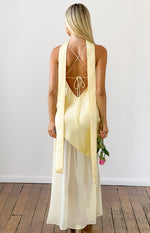 Rear view of a yellow satin maxi dress with criss-cross back straps, a low scoop back, and long scarf ties