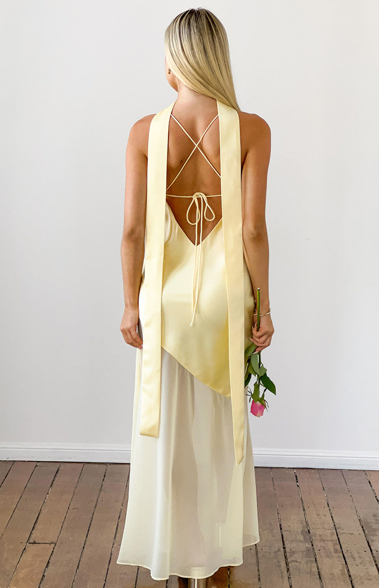 Rear view of a yellow satin maxi dress with criss-cross back straps, a low scoop back, and long scarf ties