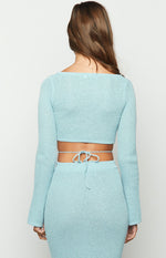 Rear view of a light blue long sleeve knit top with a wide square back neckline, cropped hem, and tie-back waist