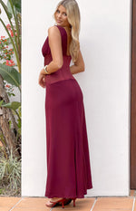 Side-rear view of a burgundy satin maxi dress with a sheer contrast panel at the waist and a flowing skirt