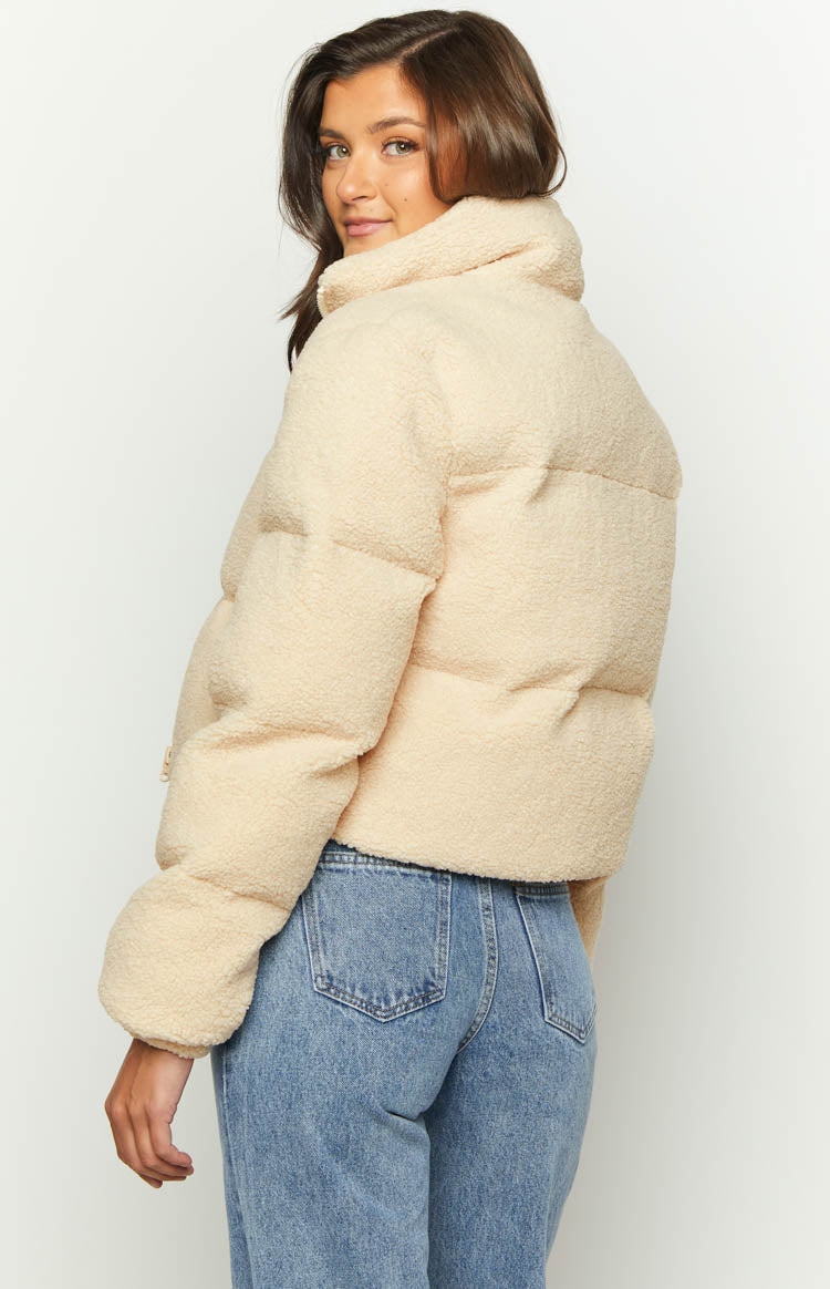 Rear view of a cream teddy puffer jacket, highlighting the textured fabric and high stand collar